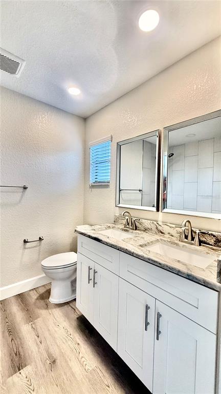 18917 Parade Road Hudson, FL 34667 - Photo 20 of 39 a bathroom with a granite countertop toilet sink and mirror
