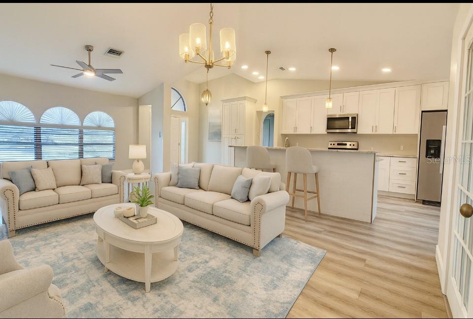 18917 Parade Road Hudson, FL 34667 - Photo 5 of 39 a living room with furniture kitchen and a chandelier