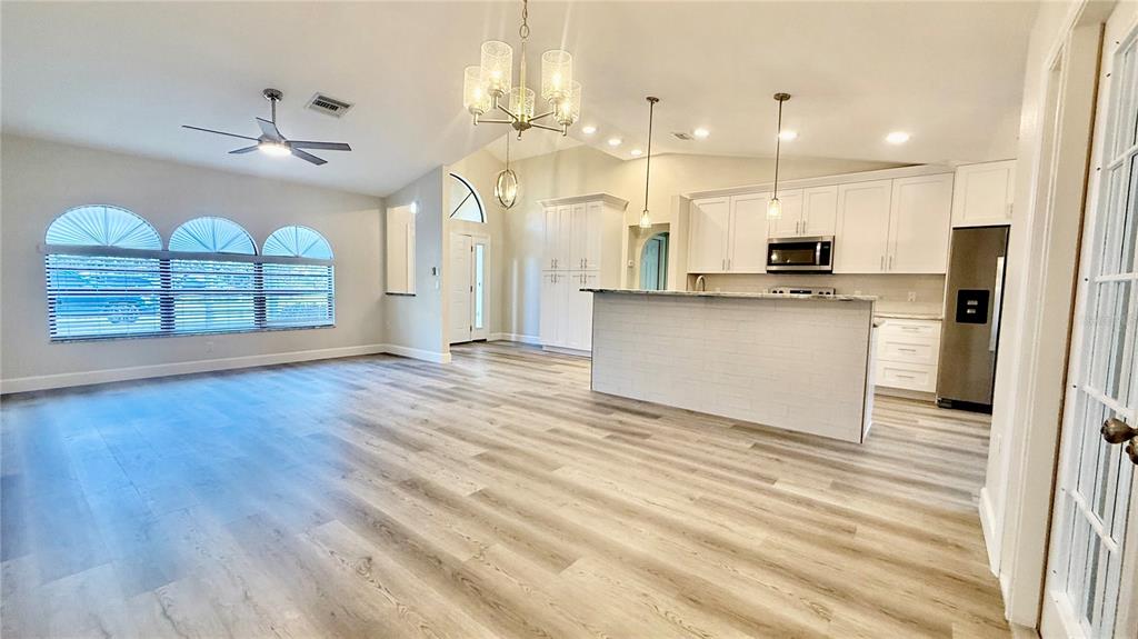18917 Parade Road Hudson, FL 34667 - Photo 6 of 39 a open kitchen with stainless steel appliances granite countertop a refrigerator a stove a oven and a wooden floors