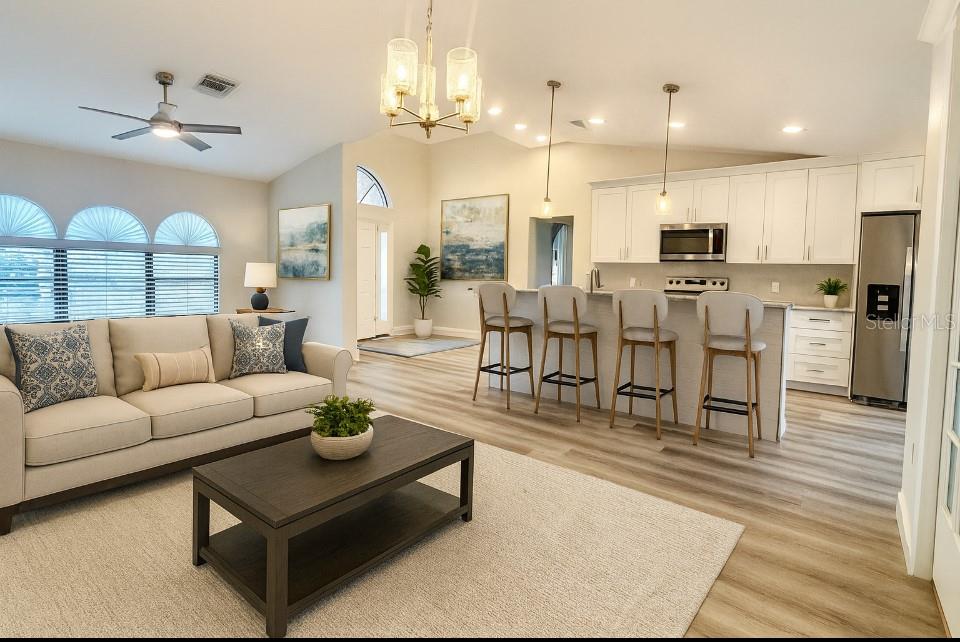 18917 Parade Road Hudson, FL 34667 - Photo 9 of 39 a living room with furniture kitchen view and a chandelier