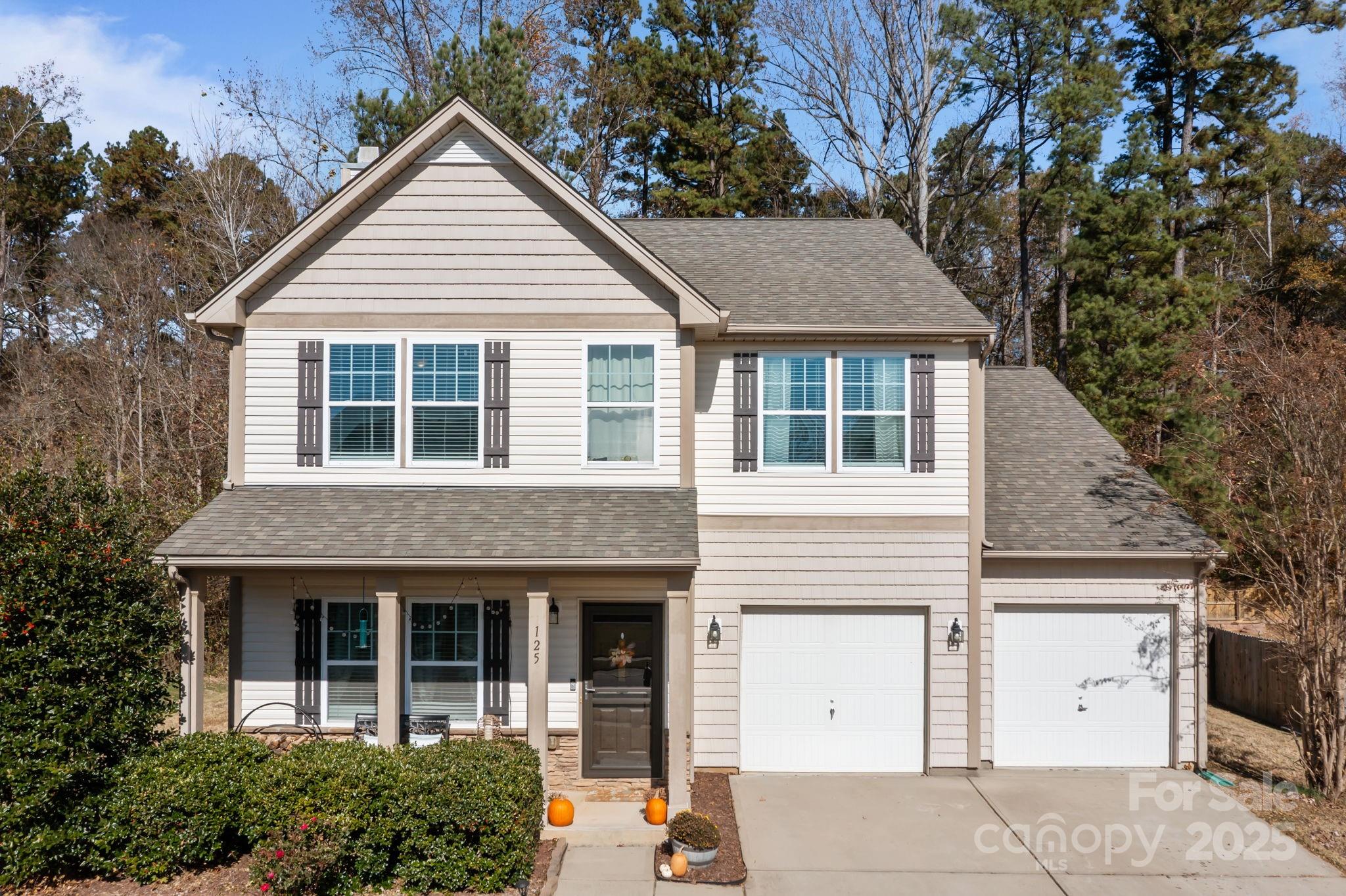 125 Devynn Ridge Court Mount Holly, NC 28120 - Photo 2 of 47 a view of a white house with large windows and a small yard