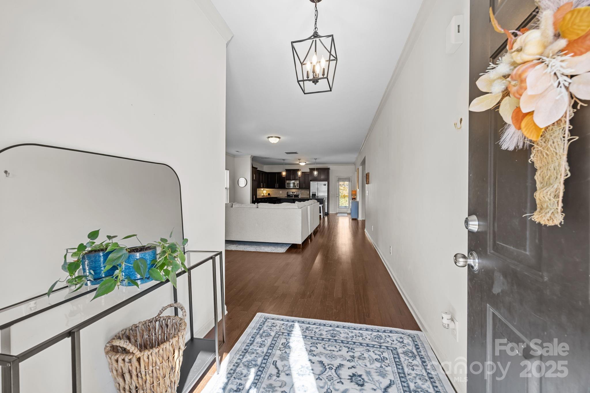 125 Devynn Ridge Court Mount Holly, NC 28120 - Photo 3 of 47 a view of a hallway to a livingroom with furniture wooden floor and a chandelier