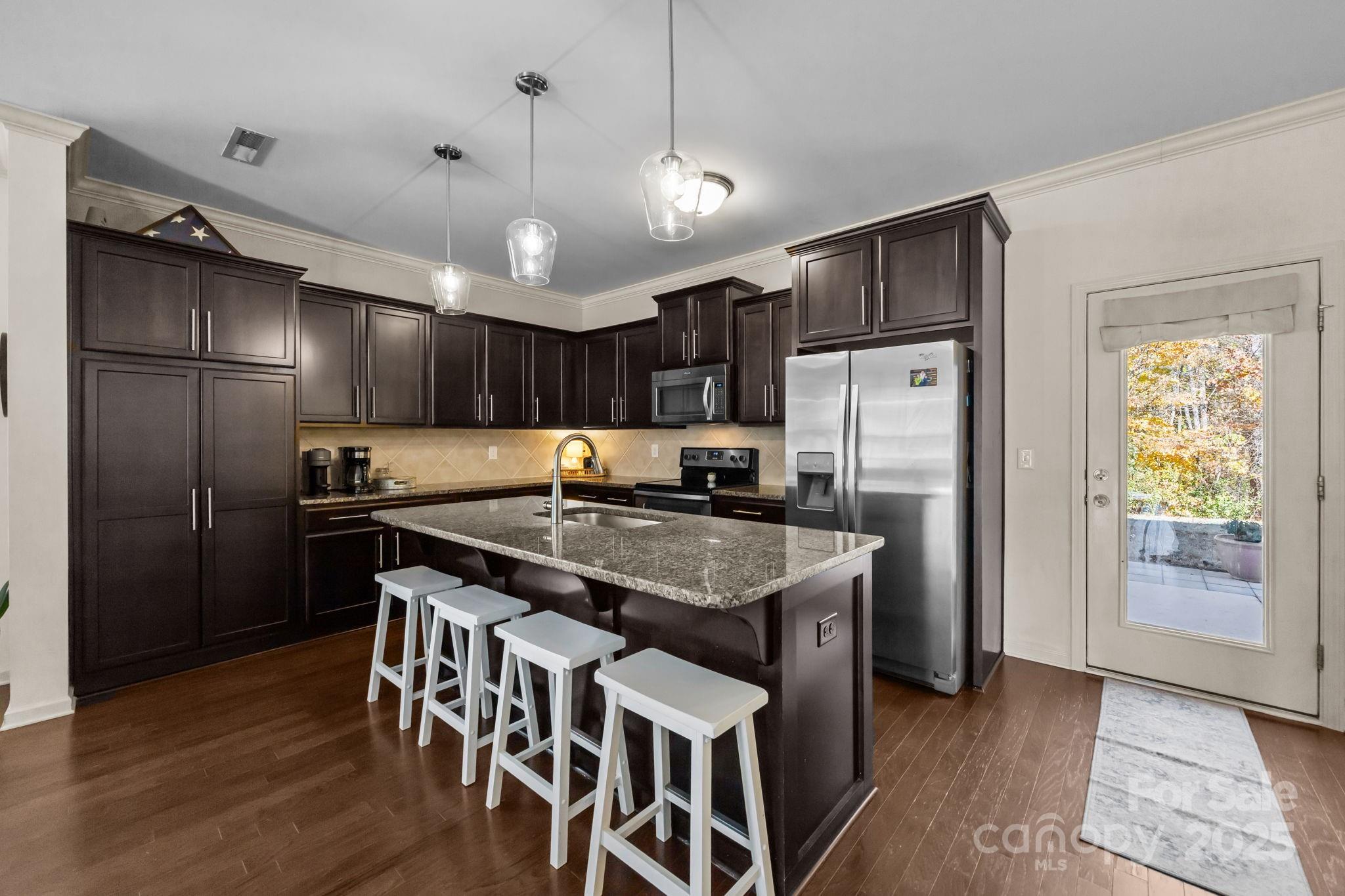125 Devynn Ridge Court Mount Holly, NC 28120 - Photo 36 of 47 a kitchen with stainless steel appliances granite countertop a table chairs refrigerator and microwave