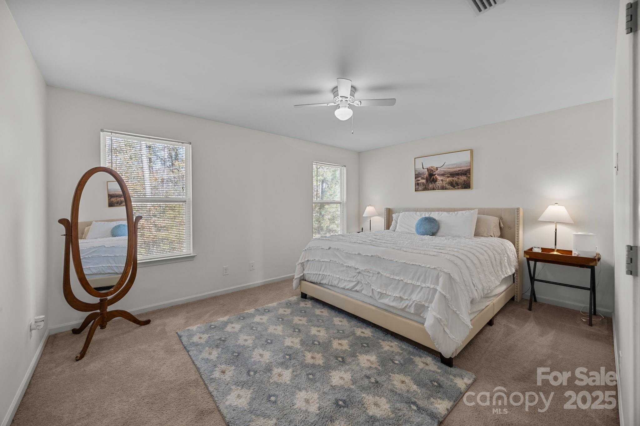 125 Devynn Ridge Court Mount Holly, NC 28120 - Photo 4 of 47 a spacious bedroom with a bed a table and painting on the wall