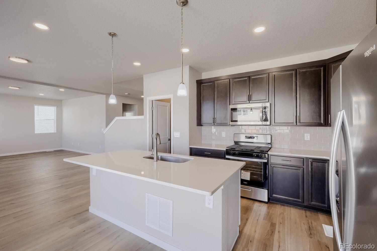 471 Atchison Way Calhan, CO 80808 - Photo 15 of 31 a kitchen with stainless steel appliances granite countertop a sink a stove and a refrigerator