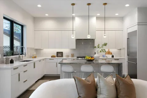 a kitchen with stainless steel appliances granite countertop a sink a stove and cabinets