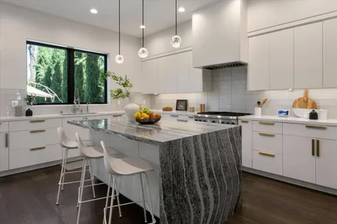 a kitchen with a sink a stove and cabinets
