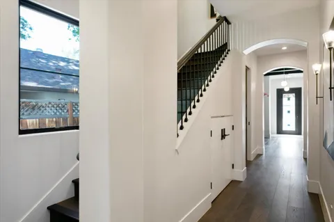 a view of a hallway with wooden floor and staircase