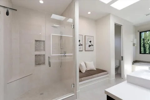 a bathroom with a sink and a large mirror with shower