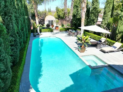 an aerial view of a house with swimming pool and garden