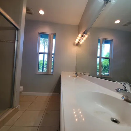 a view of a hallway with wooden floor and a living room