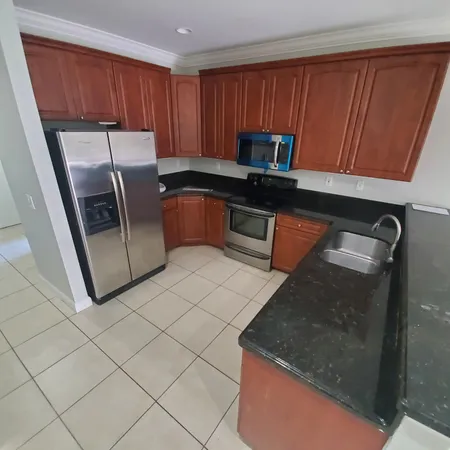 a kitchen with granite countertop stainless steel appliances a stove a microwave a sink and a cabinets