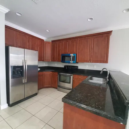 a kitchen with granite countertop a refrigerator and a sink