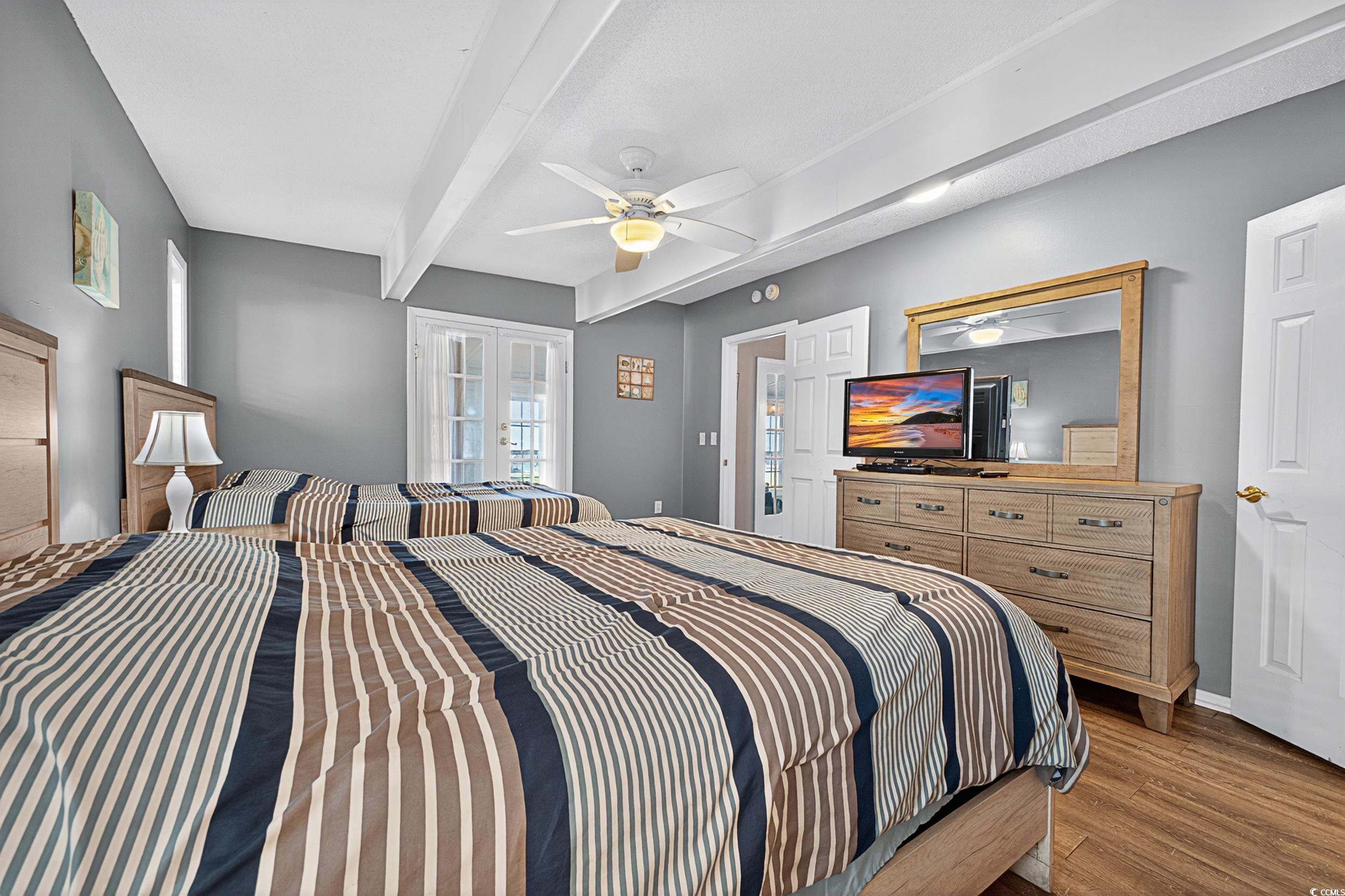 1885 Pompano Drive Murrells Inlet, SC 29576 - Photo 14 of 34 Bedroom with wood finished floors, french doors, beamed ceiling, and a ceiling fan