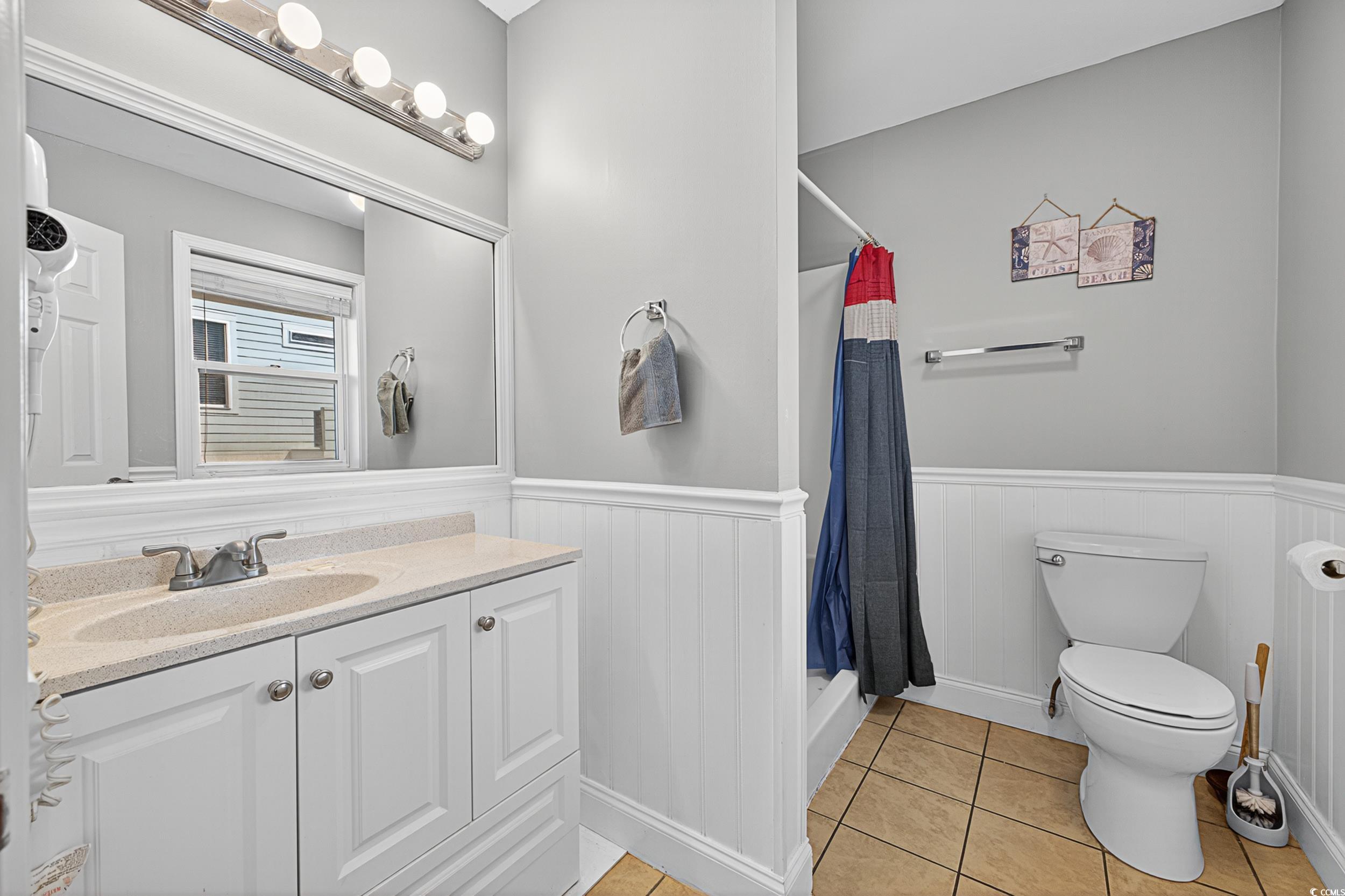 1885 Pompano Drive Murrells Inlet, SC 29576 - Photo 20 of 34 Full bath featuring vanity, wainscoting, tile patterned flooring, and a shower with curtain