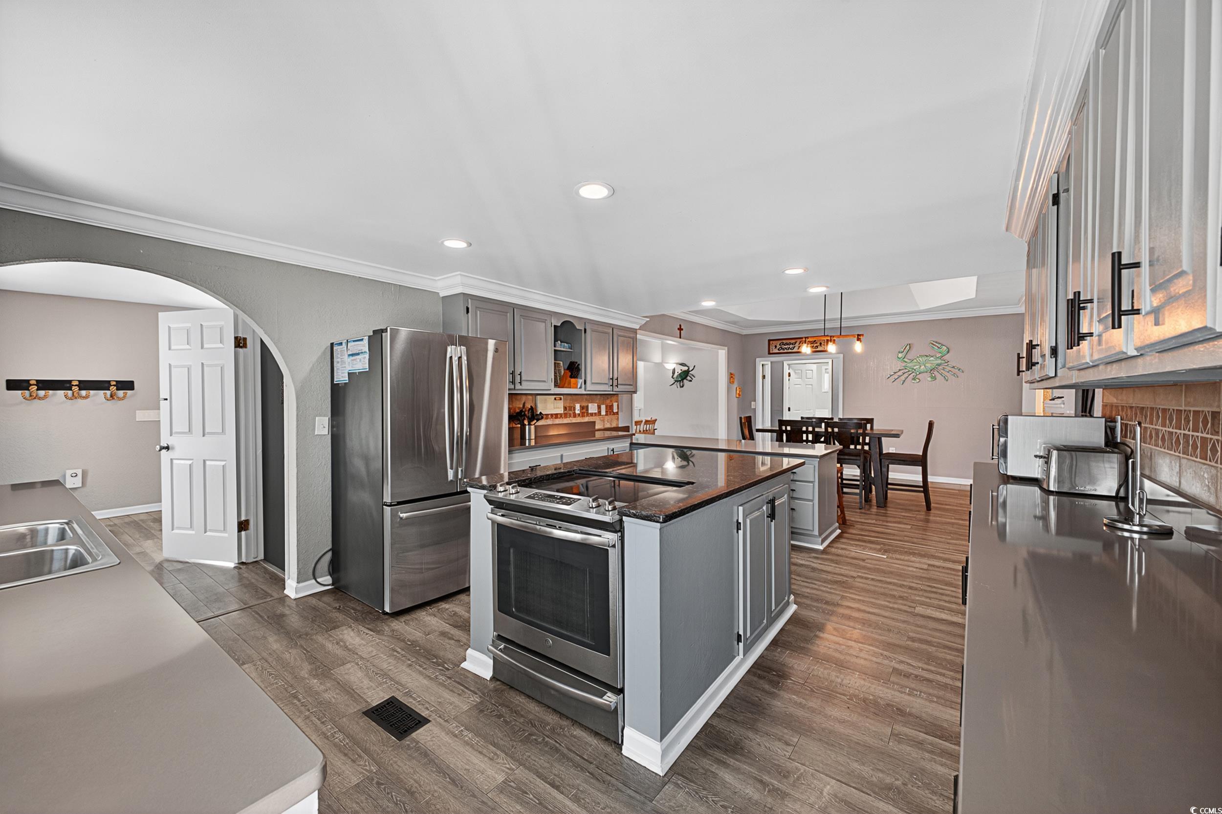 1885 Pompano Drive Murrells Inlet, SC 29576 - Photo 28 of 34 Kitchen with appliances with stainless steel finishes, a center island, crown molding, dark countertops, and gray cabinets