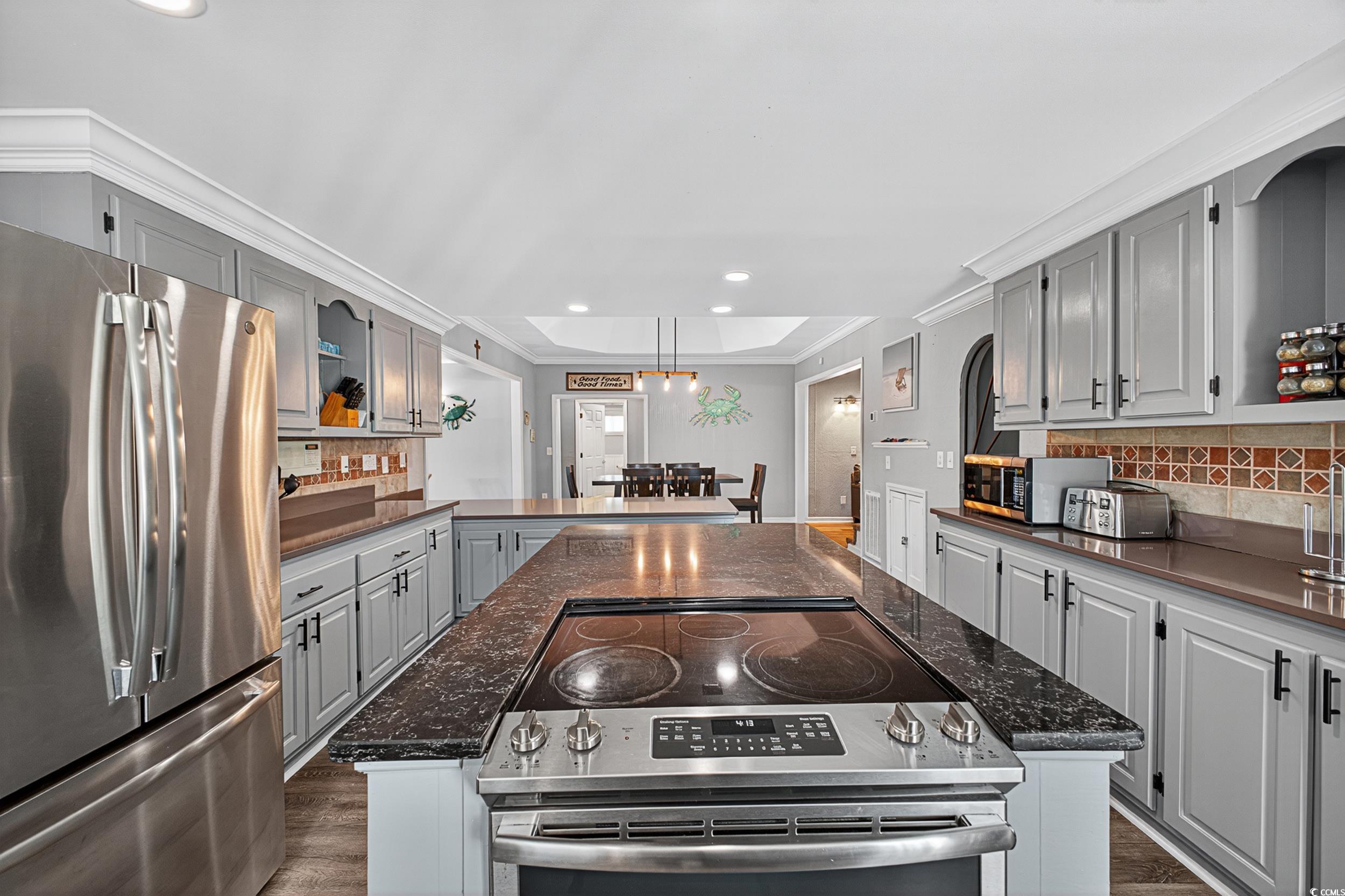 1885 Pompano Drive Murrells Inlet, SC 29576 - Photo 29 of 34 Kitchen featuring appliances with stainless steel finishes, gray cabinetry, a kitchen island, backsplash, and recessed lighting