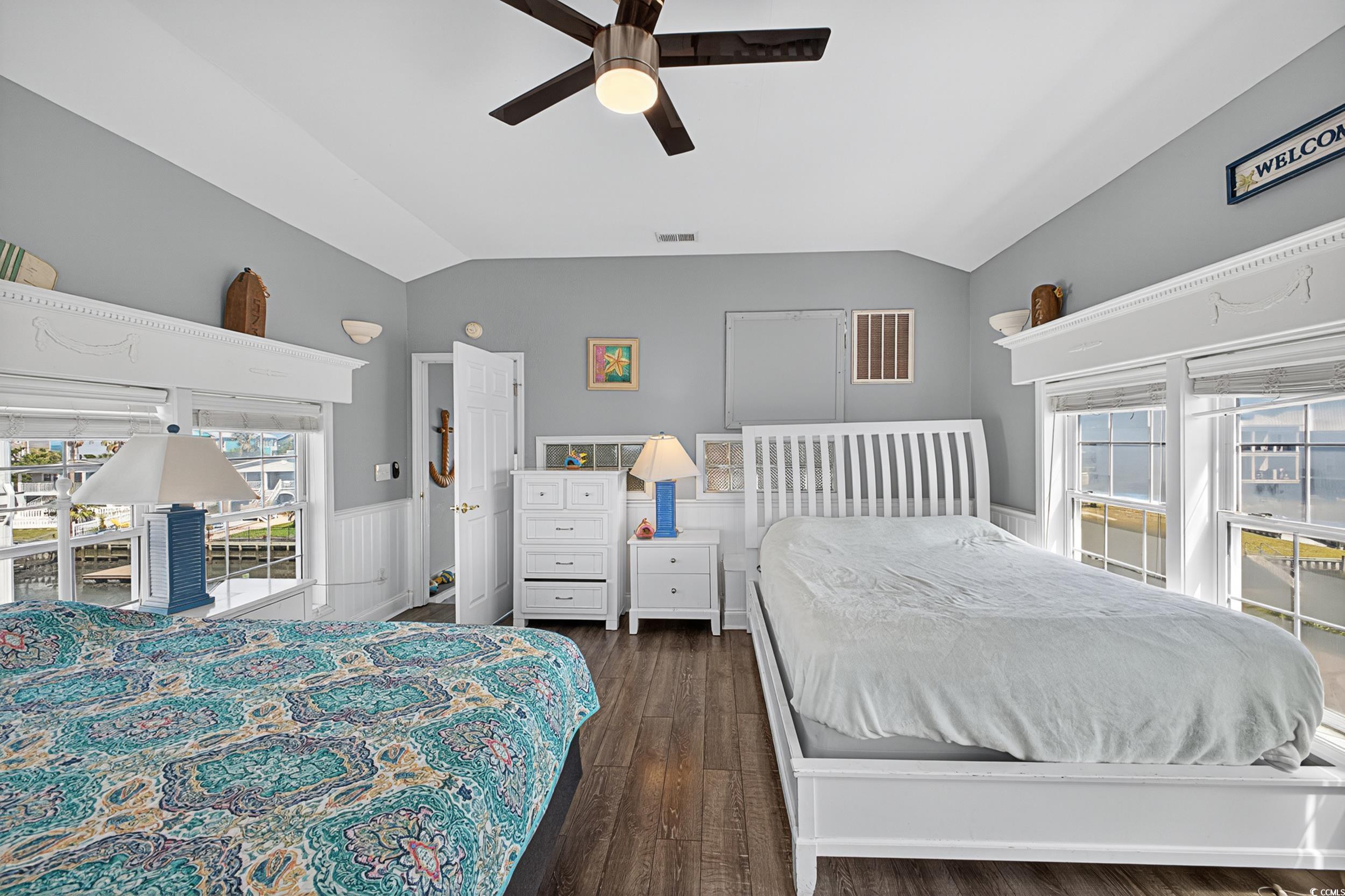 1885 Pompano Drive Murrells Inlet, SC 29576 - Photo 9 of 34 Bedroom featuring lofted ceiling, dark wood-style floors, a wainscoted wall, and a ceiling fan