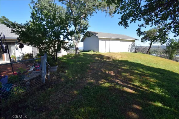 a backyard of a house with plants and large trees