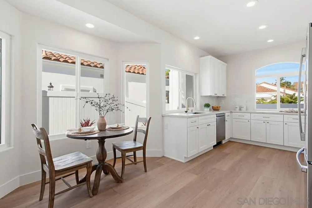 4959 Lamia Way Oceanside, CA 92056 - Photo 18 of 63 a kitchen with a dining table chairs and white appliances