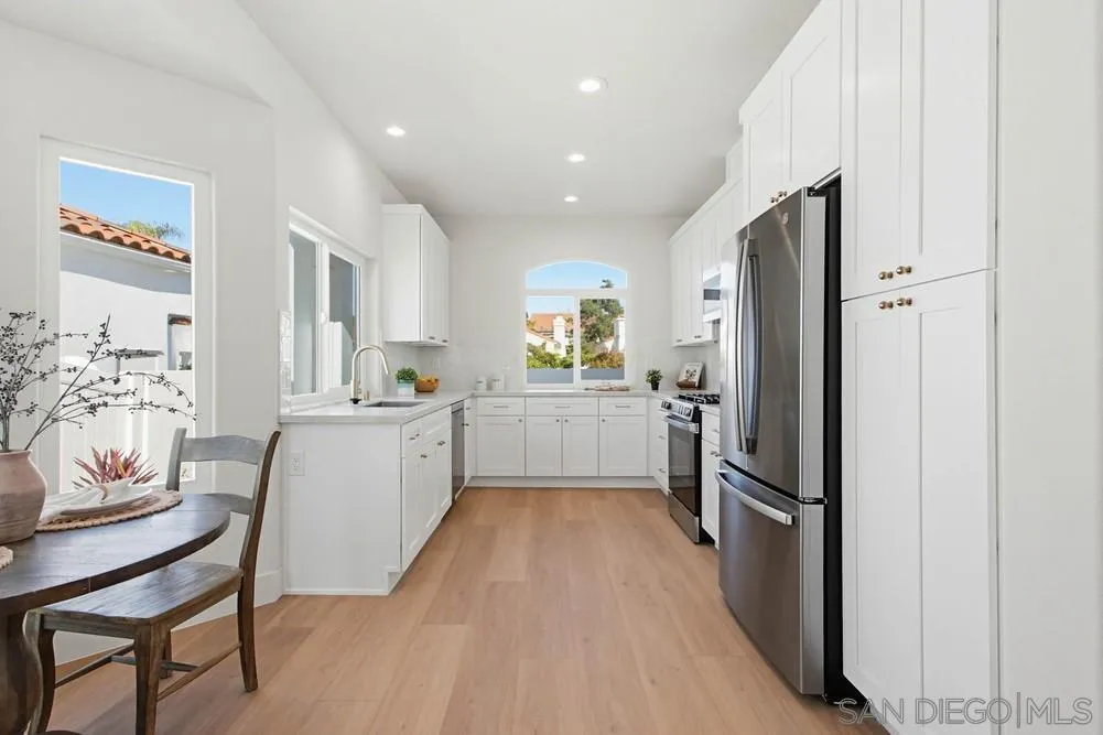 4959 Lamia Way Oceanside, CA 92056 - Photo 19 of 63 a kitchen with white cabinets and stainless steel appliances