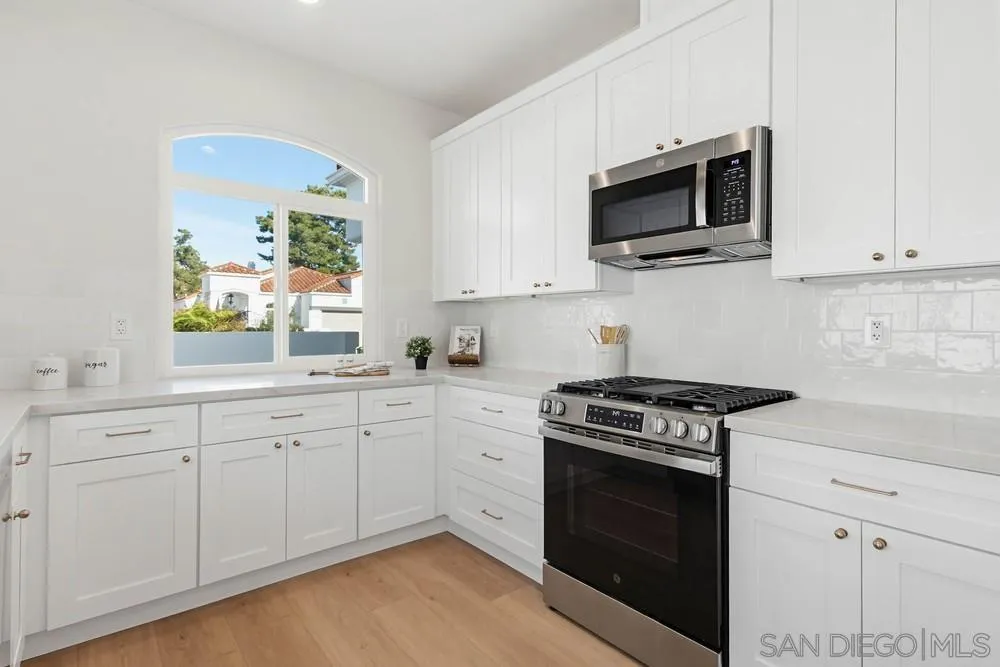 4959 Lamia Way Oceanside, CA 92056 - Photo 23 of 63 a kitchen with cabinets stainless steel appliances and wooden floor