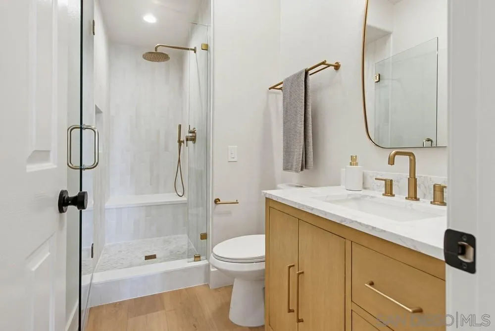 4959 Lamia Way Oceanside, CA 92056 - Photo 50 of 63 a bathroom with a granite countertop sink toilet a shower and a mirror