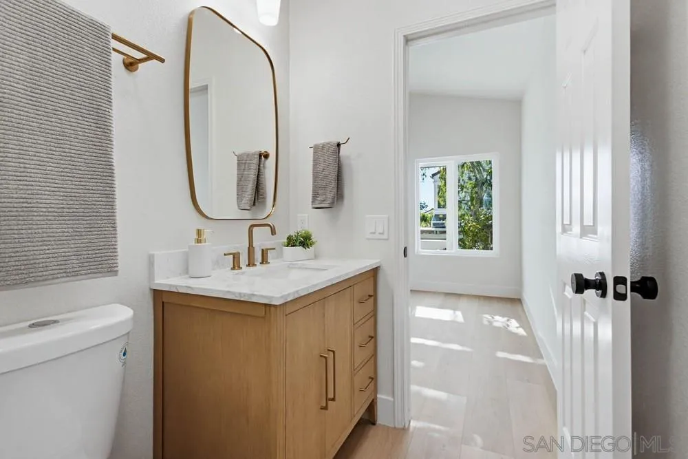 4959 Lamia Way Oceanside, CA 92056 - Photo 51 of 63 a bathroom with a granite countertop sink a toilet and a mirror