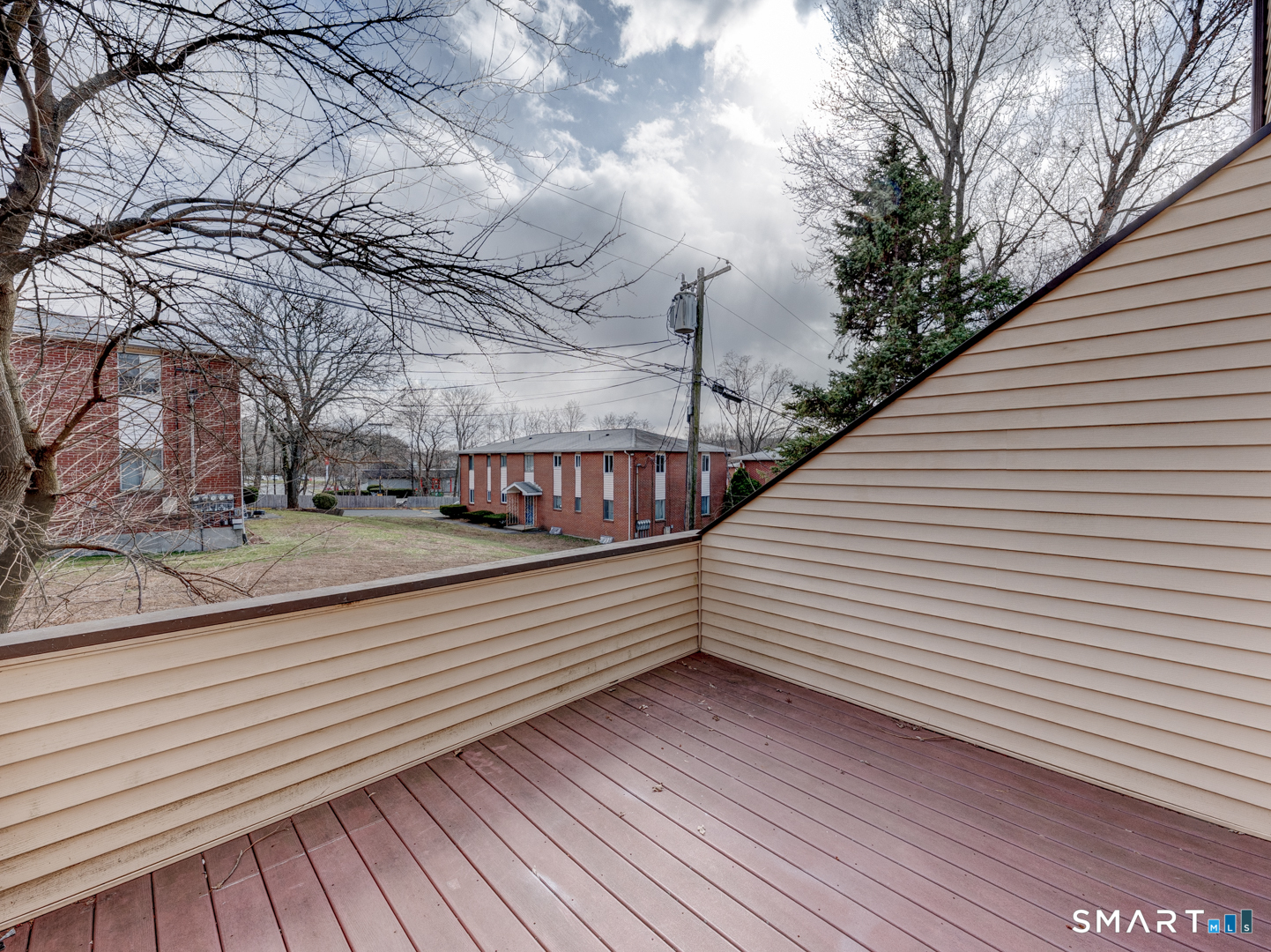 285 Queen Street, Unit 1C Southington, CT 06489 - Photo 13 of 33 a view of a balcony with wooden floor and fence and a bench