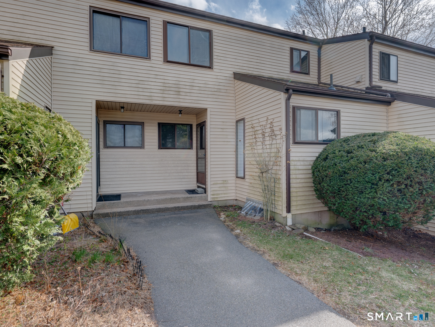 285 Queen Street, Unit 1C Southington, CT 06489 - Photo 2 of 33 a view of a house with a small yard and a garage