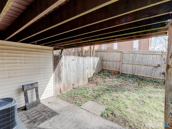 a backyard of a house with a small barn and wooden floor