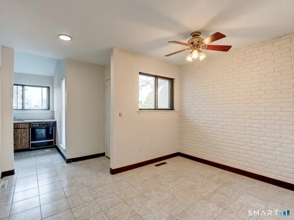en empty room with windows and ceiling fan