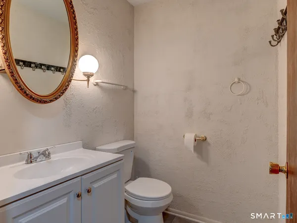 a bathroom with a granite countertop toilet a sink and a mirror