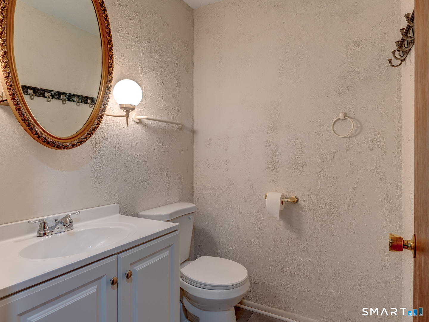 285 Queen Street, Unit 1C Southington, CT 06489 - Photo 10 of 33 a bathroom with a granite countertop toilet a sink and a mirror