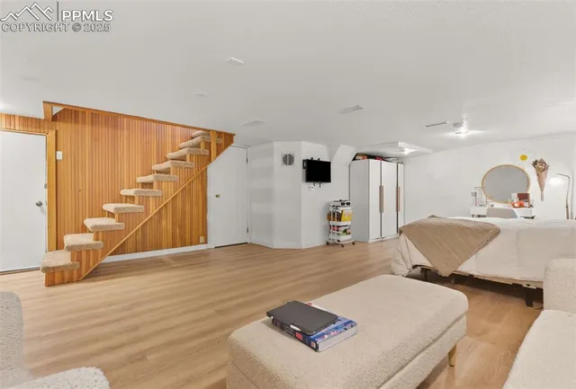 a spacious bedroom with a bed and a wooden floor