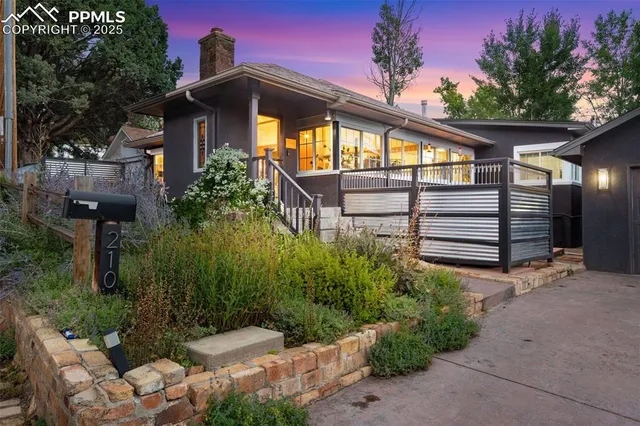 a view of a house with a large windows and flower plants
