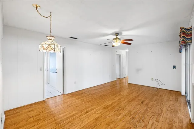 a view of empty room with a window and ceiling fan