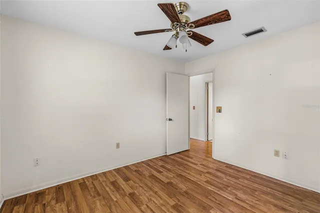 a view of a big room with wooden floor and a ceiling fan