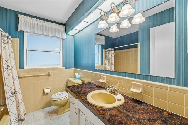 a bathroom with a granite countertop sink mirror vanity and toilet