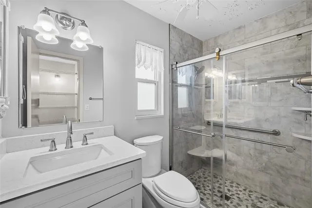 a bathroom with a sink toilet a mirror and shower