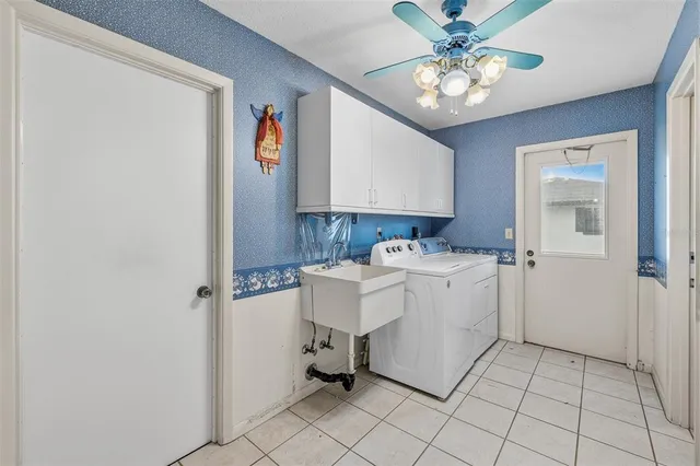 a utility room with cabinets washer and dryer