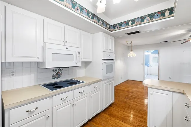 a kitchen with white cabinets and sink