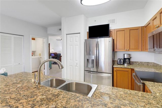 a kitchen with granite countertop a refrigerator and a sink