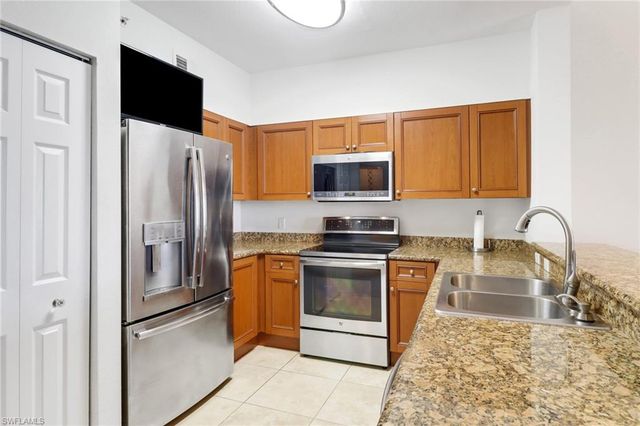 a kitchen with stainless steel appliances granite countertop a refrigerator stove and microwave