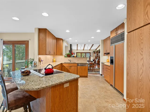 a kitchen with stainless steel appliances granite countertop a refrigerator and a stove top oven