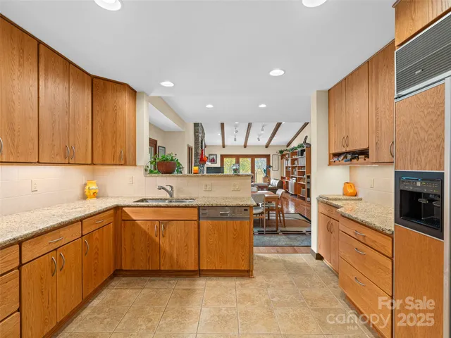 a kitchen with stainless steel appliances granite countertop a sink refrigerator and cabinets