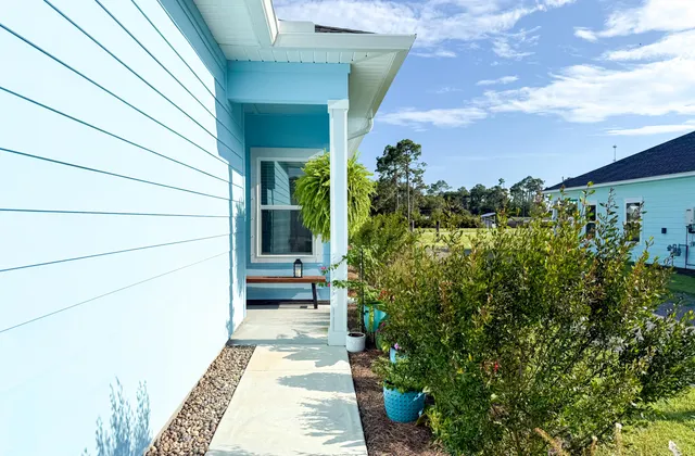 a view of a pathway of a house with potted plants