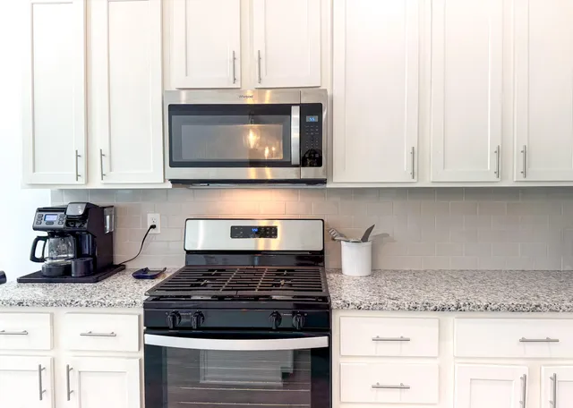 a kitchen with granite countertop a stove top oven cabinetry a sink and dishwasher