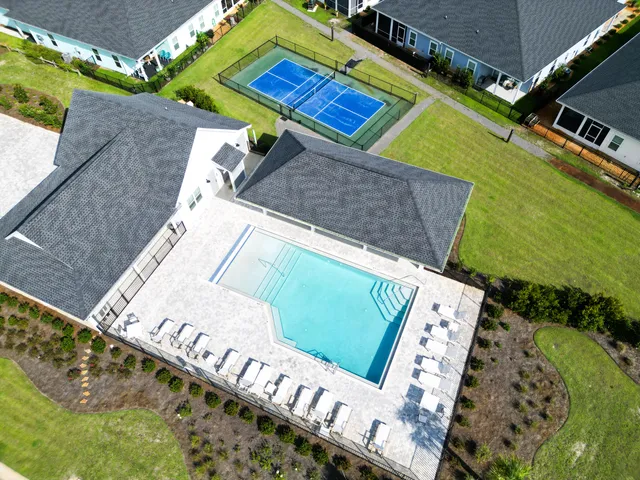 a aerial view of a house next to a big yard and large trees