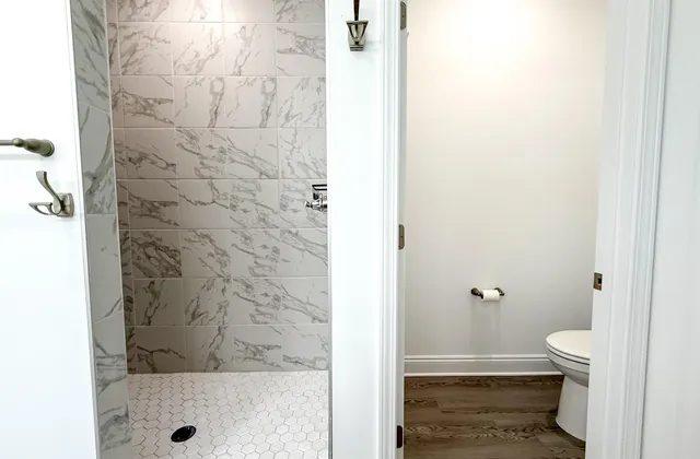 a bathroom with a granite countertop shower and a toilet